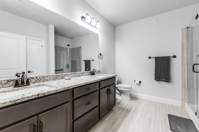 bathroom with double vanity, a sink, and a stall shower