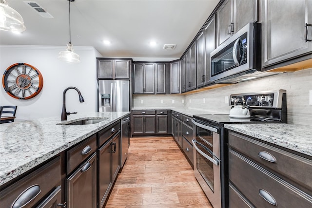 kitchen featuring visible vents, dark brown cabinetry, light stone countertops, a sink, and stainless steel appliances