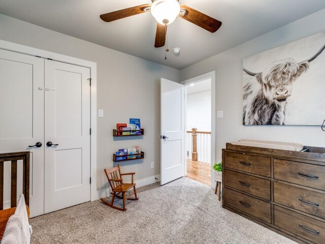 bedroom featuring a ceiling fan, baseboards, light carpet, and a closet