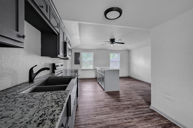 kitchen with light stone countertops, appliances with stainless steel finishes, a sink, a ceiling fan, and dark wood-style floors