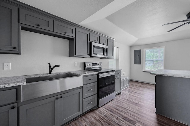 kitchen with light stone countertops, ceiling fan, a sink, dark wood finished floors, and stainless steel appliances