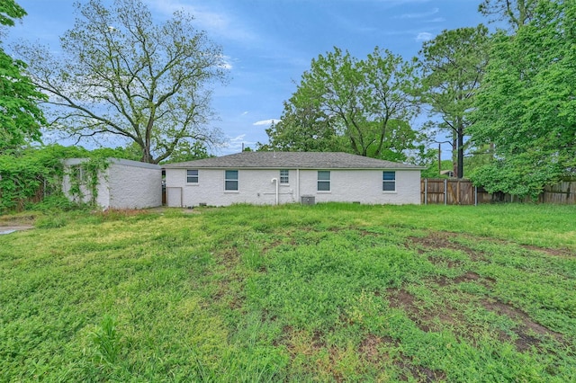 back of house with a yard, fence, and central air condition unit