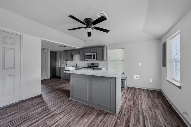 kitchen featuring gray cabinets, a kitchen island, stainless steel appliances, and dark wood-type flooring