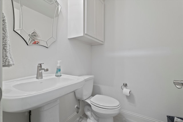 bathroom with toilet and baseboards