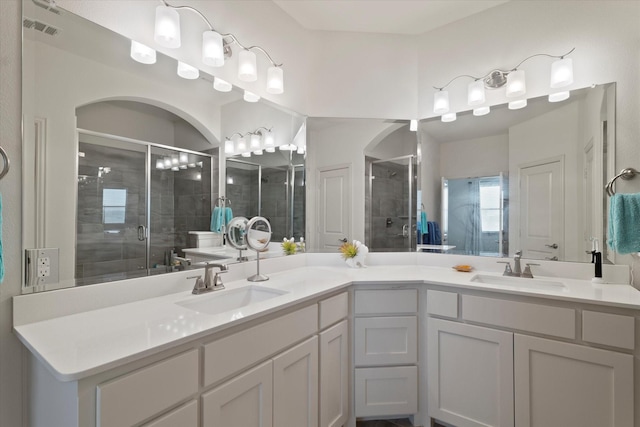 bathroom with a sink, a stall shower, and visible vents