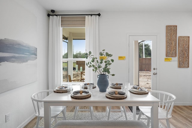 dining room featuring baseboards and light wood-style flooring