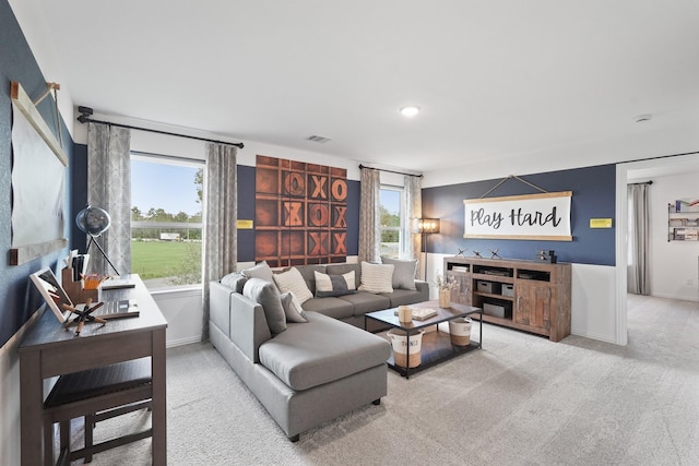 living room featuring visible vents, carpet, and baseboards
