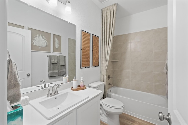 full bathroom featuring toilet, bathtub / shower combination, wood finished floors, and vanity