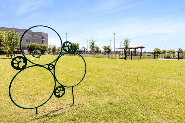 view of home's community featuring a lawn and fence