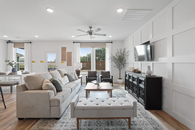 living room with recessed lighting, a ceiling fan, light wood finished floors, and visible vents