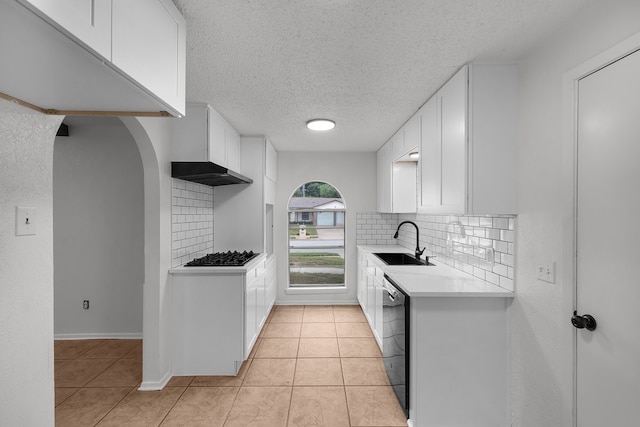 kitchen featuring a sink, light countertops, a textured ceiling, tasteful backsplash, and black appliances