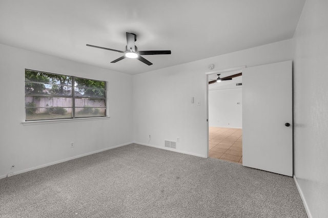 unfurnished room featuring visible vents, a ceiling fan, baseboards, and carpet floors