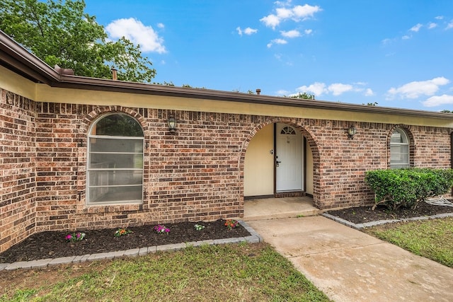 view of exterior entry with brick siding