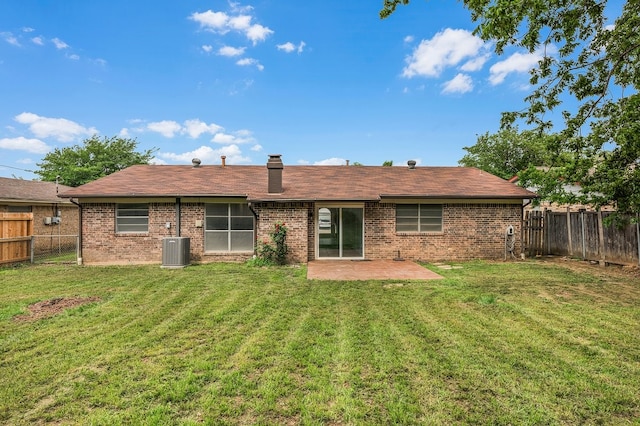 rear view of house with a lawn, brick siding, central AC, a fenced backyard, and a patio