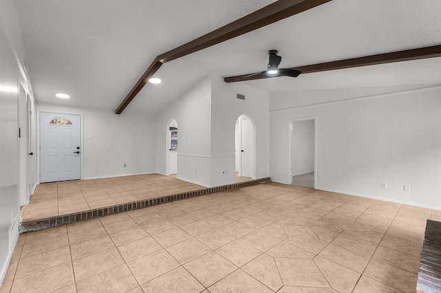 unfurnished living room with a ceiling fan, visible vents, arched walkways, vaulted ceiling with beams, and light tile patterned flooring