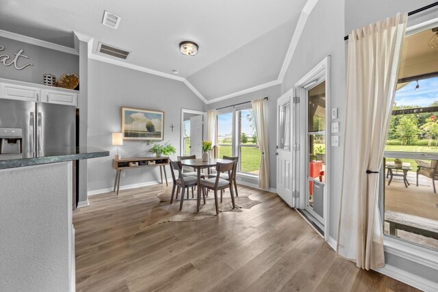 dining area with crown molding, baseboards, visible vents, and lofted ceiling