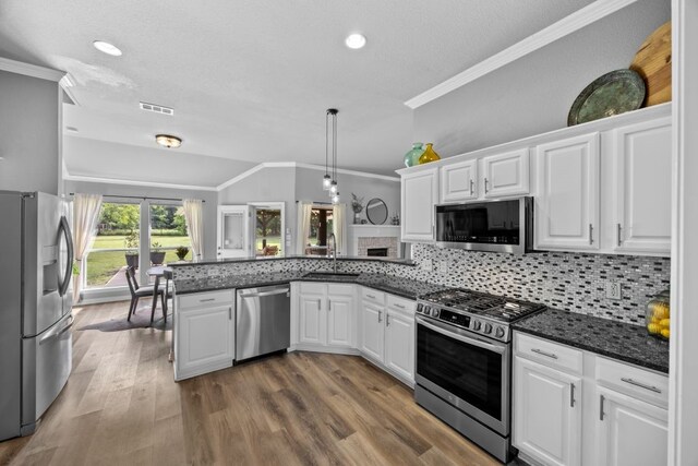 kitchen featuring crown molding, appliances with stainless steel finishes, a peninsula, white cabinetry, and visible vents