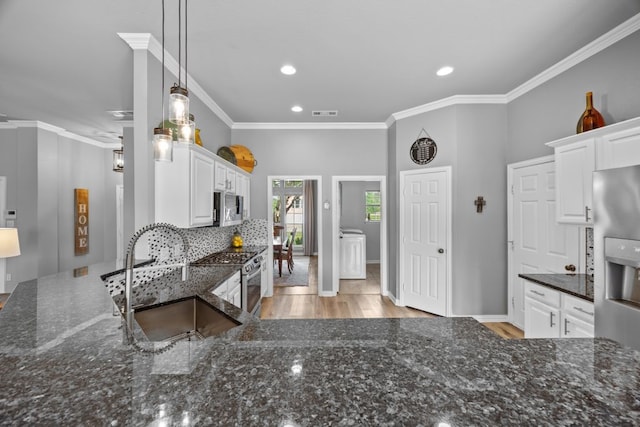 kitchen featuring white cabinets, a sink, dark stone counters, stainless steel appliances, and recessed lighting