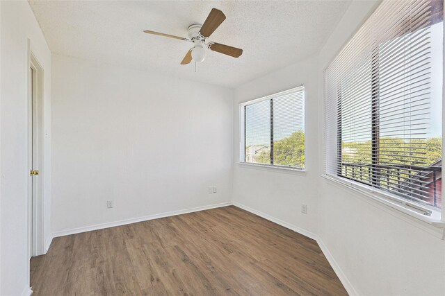 spare room with baseboards, a textured ceiling, ceiling fan, and wood finished floors