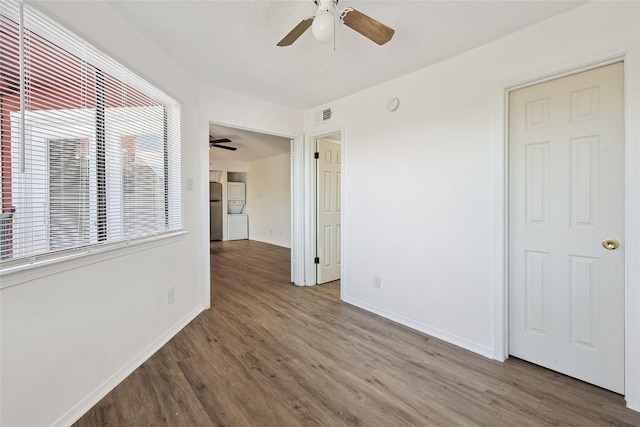 unfurnished room with visible vents, a ceiling fan, and wood finished floors