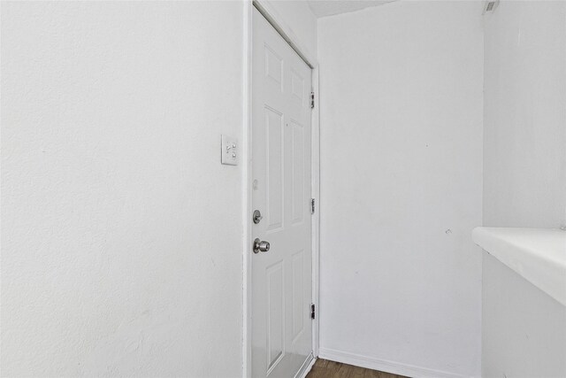 doorway featuring baseboards and dark wood finished floors