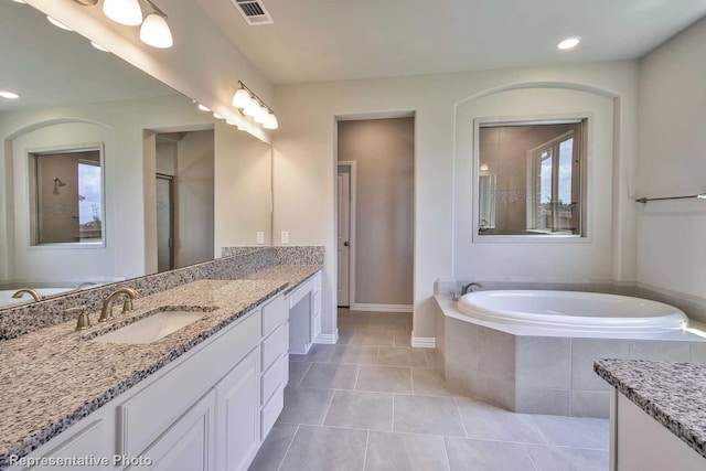 bathroom with visible vents, a garden tub, vanity, baseboards, and tile patterned floors