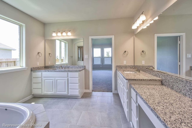 full bath featuring a sink, baseboards, and two vanities
