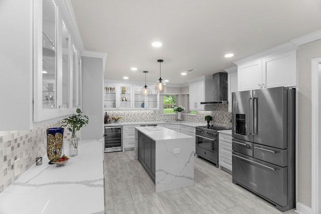 kitchen with wall chimney range hood, beverage cooler, premium appliances, and decorative backsplash
