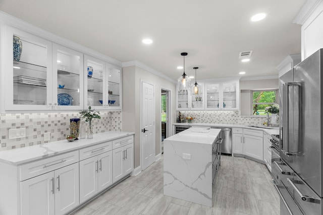 kitchen with crown molding, appliances with stainless steel finishes, decorative backsplash, and visible vents