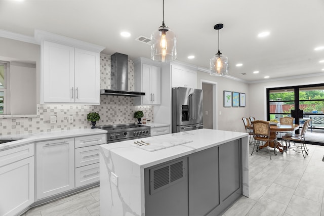 kitchen with crown molding, backsplash, high end appliances, and wall chimney range hood