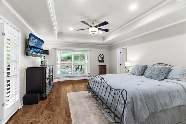 bedroom with ceiling fan, ornamental molding, wood finished floors, and a raised ceiling