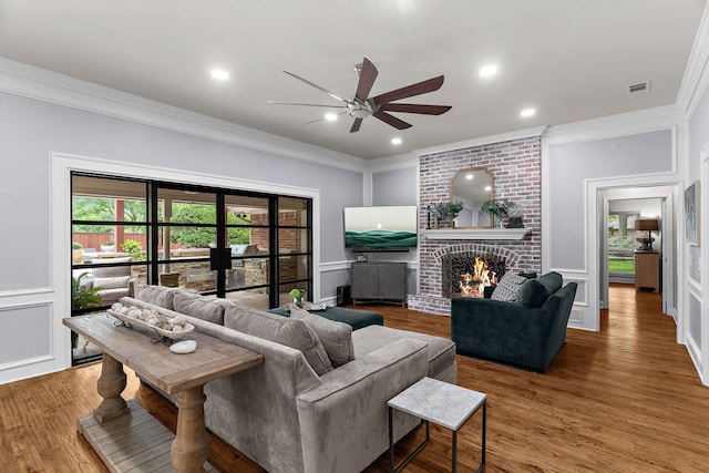living area featuring crown molding, ceiling fan, and a decorative wall