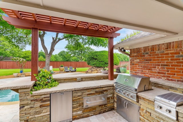 view of patio / terrace with exterior kitchen, fence, a pergola, and a grill