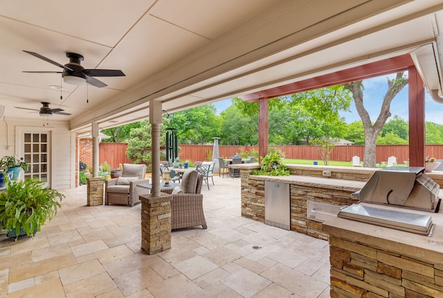 view of patio featuring a grill, outdoor dining area, a fenced backyard, an outdoor hangout area, and exterior kitchen