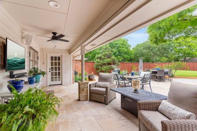 view of patio with an outdoor living space, a ceiling fan, outdoor dining area, and a fenced backyard