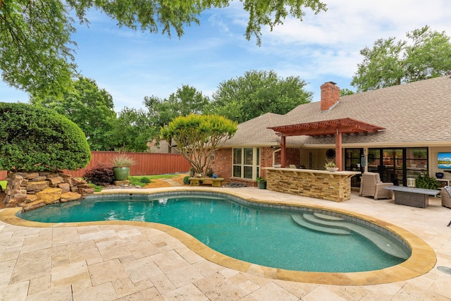 view of swimming pool featuring a fenced in pool, a patio area, fence, and outdoor dry bar