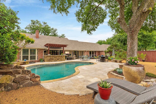 pool featuring a patio area, fence, a pergola, and outdoor dry bar