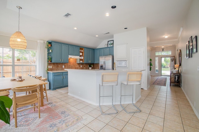 kitchen featuring open shelves, stainless steel fridge with ice dispenser, blue cabinetry, backsplash, and visible vents