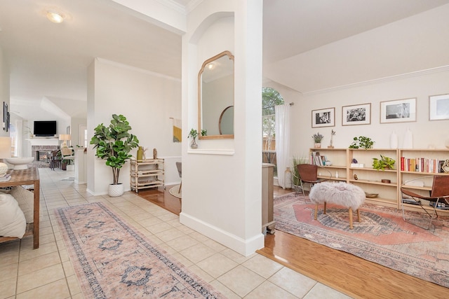 corridor featuring crown molding, tile patterned floors, and baseboards