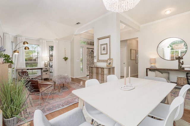 dining room with ornamental molding, light wood finished floors, and a chandelier