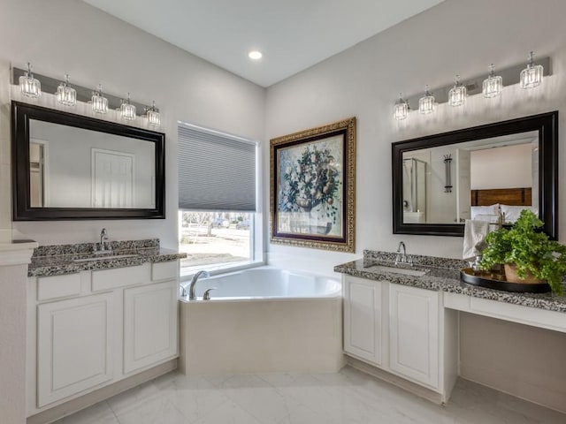 bathroom featuring a sink, marble finish floor, and a garden tub