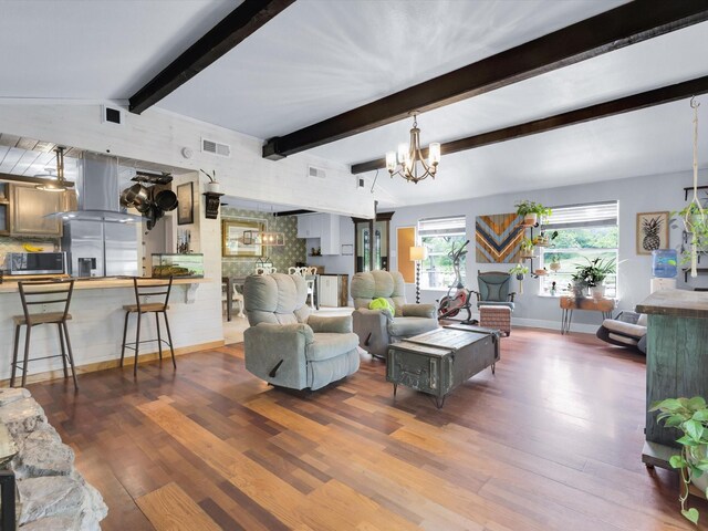 living area featuring visible vents, an inviting chandelier, wood finished floors, beamed ceiling, and baseboards