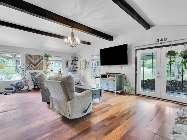 living area featuring wood-type flooring, a chandelier, french doors, and beamed ceiling