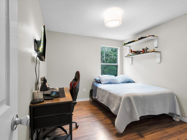 bedroom with baseboards and wood finished floors