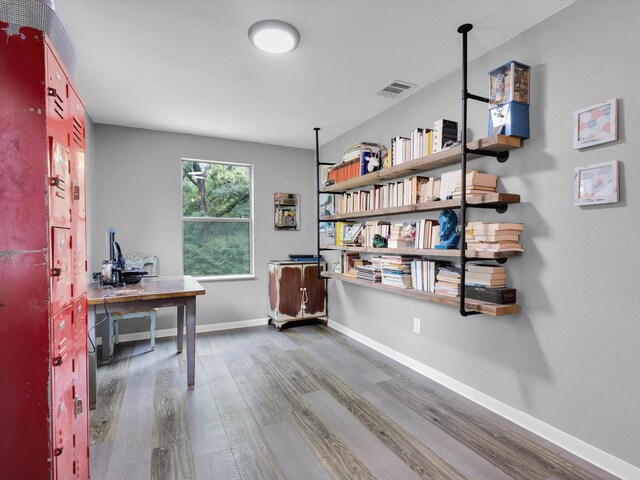 home office with baseboards, wood finished floors, and visible vents