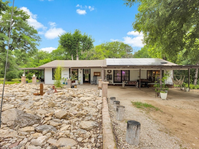 rear view of property with solar panels