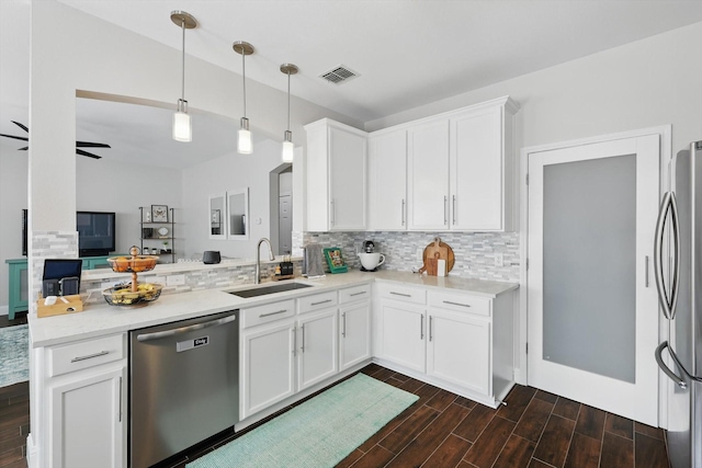 kitchen featuring a sink, appliances with stainless steel finishes, decorative backsplash, and dark wood-style floors