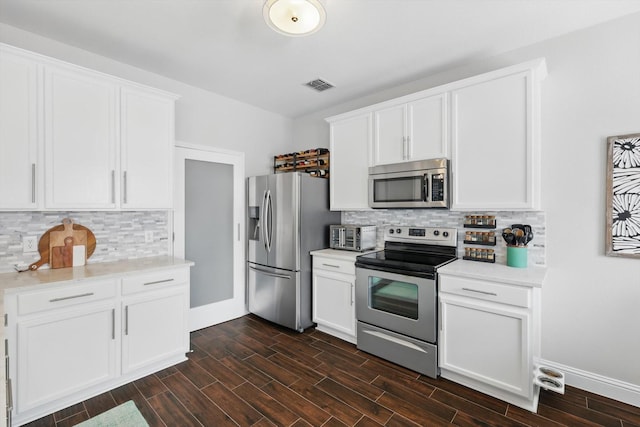 kitchen with visible vents, light countertops, white cabinets, tasteful backsplash, and stainless steel appliances