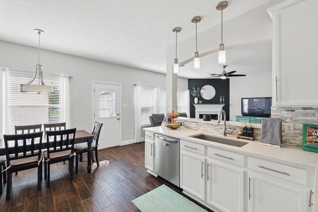 kitchen featuring ceiling fan, backsplash, a fireplace, dishwasher, and a sink