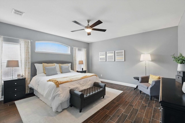 bedroom featuring baseboards, a ceiling fan, wood finished floors, and visible vents